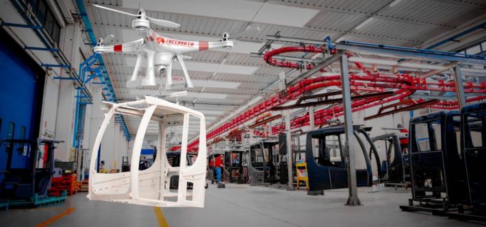 Una cabina per macchine movimento terra viene trasportata con un drone, all'interno della nostra azienda.